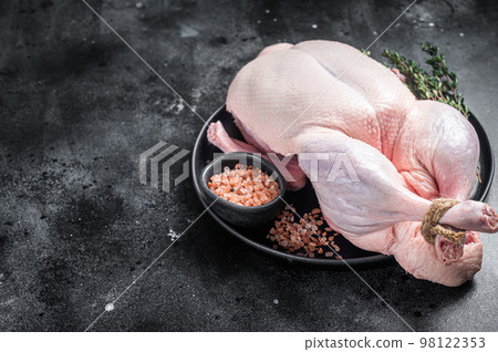 Organic eco uncooked whole duck with thyme and salt. Black background. Top view. Copy space 98122353