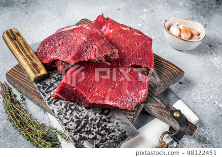 Raw Venison dear meat on butcher cutting board, game meat. Gray background. Top view 98122451
