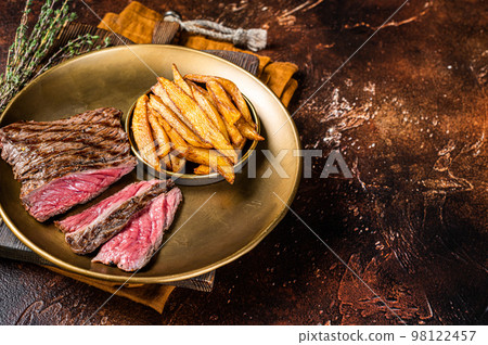 Elk steak with herbs and french fry, game meat. Dark background. Top view. Copy space 98122457