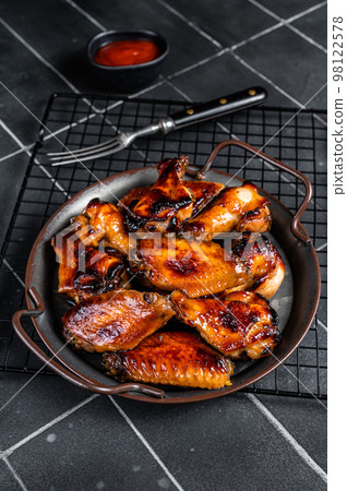 BBQ chicken wings in dip Barbecue sauce. Black background. Top view 98122578