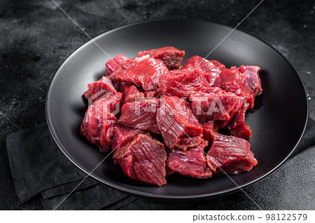 Raw Diced game meat of wild venison dear. Black background. Top view 98122579