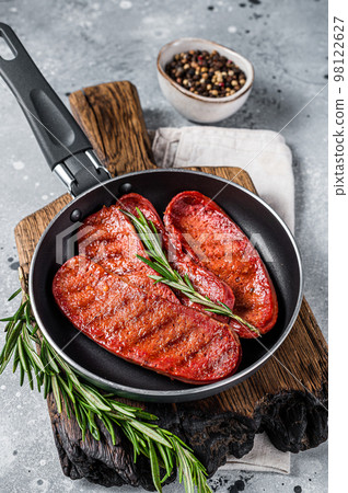 Cooking of Turkish Sucuk beef meat sausage in a skillet. Gray background. Top view 98122627