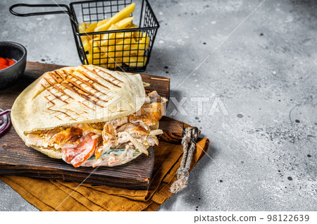 Doner kebab, Shawarma in grilled pita bread with vegetables and meat. Gray background. Top view. Copy space 98122639
