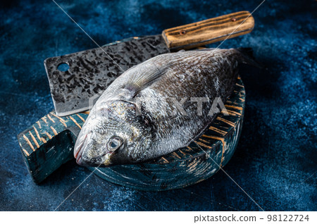 Sea bream or dorado fish on fish market cutting board. Blue background. Top view Sea bream or dorado fish on fish market cutting board. Blue background. Top view 98122724