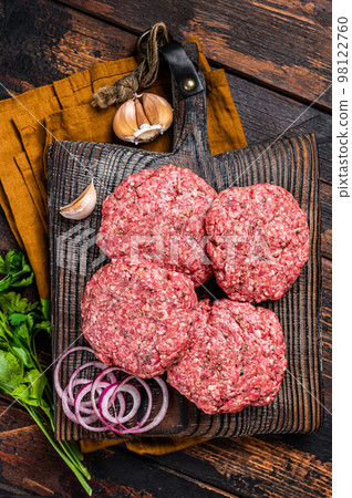 Fresh Raw burger patty, mince beef Meat, uncooked meat cutlets. Wooden background. Top view Fresh Raw burger patty, mince beef Meat, uncooked meat cutlets. Wooden background. Top view 98122760