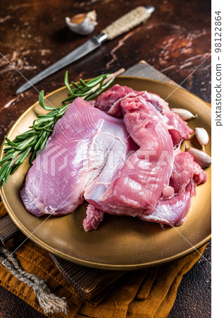 Fresh skinless raw Turkey thigh fillet meat with spices. Dark background. Top view 98122864