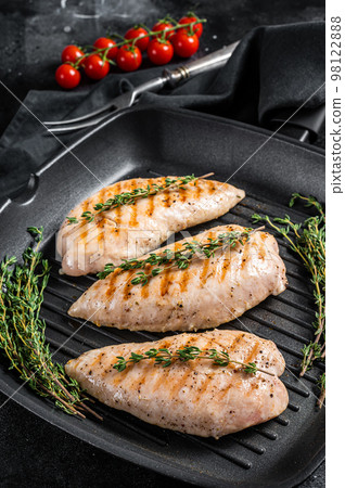 Turkey grilled breast fillet steaks in a frying pan. Black background. Top view Turkey grilled breast fillet steaks in a frying pan. Black background. Top view 98122888