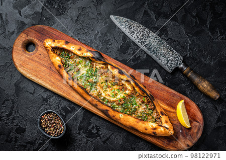 Turkish pide pie with beef meat and vegetables. Black background. Top view Turkish pide pie with beef meat and vegetables. Black background. Top view 98122971