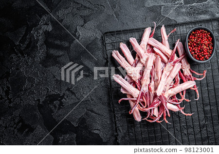 Raw Duck Tongue ready for cooking. Black background. Top view. Copy space 98123001