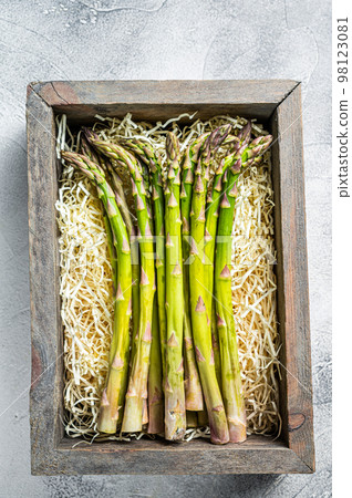 Raw green asparagus in a wooden box. White background. Top view Raw green asparagus in a wooden box. White background. Top view 98123081