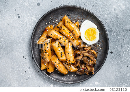 Korean Tteokbokki, Topokki fried rice cake stick in Hot and spicy sauce. Gray background. Top view Korean Tteokbokki, Topokki fried rice cake stick in Hot and spicy sauce. Gray background. Top view 98123110