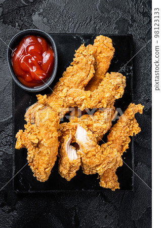 Breaded chicken strips Fingers with Ketchup. Black background. Top view Breaded chicken strips Fingers with Ketchup. Black background. Top view 98123133