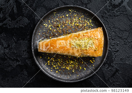 Turkish Havuc Dilim Baklava with pistachio, Carrot Slice Baklava. Black background. Top view Turkish Havuc Dilim Baklava with pistachio, Carrot Slice Baklava. Black background. Top view 98123149