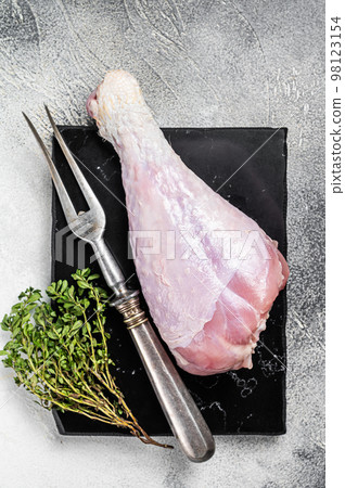 Raw turkey leg thigh with thyme and spices. White background. Top view 98123154