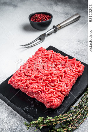 Raw mince Minced beef, ground meat with thyme and pepper. White background. Top view Raw mince Minced beef, ground meat with thyme and pepper. White background. Top view 98123298
