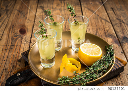 Limoncello shots, Italian lemon liqueur. Wooden background. Top view Limoncello shots, Italian lemon liqueur. Wooden background. Top view 98123301