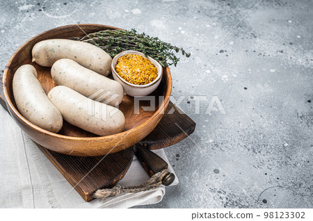 Bavarian white sausage in wooden plate with mustard. Gray background. Top view. Copy space 98123302