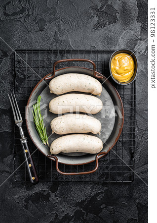 Traditional German Bavarian white sausage in steel tray with mustard. Black background. Top view Traditional German Bavarian white sausage in steel tray with mustard. Black background. Top view 98123331