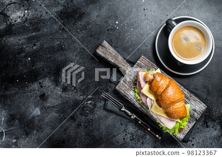 Croissant Club Sandwich with Ham and Cheese, cup of coffe. Black background. Top view. Copy space Croissant Club Sandwich with Ham and Cheese, cup of coffe. Black background. Top view. Copy space 98123367