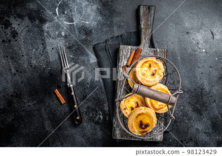 Traditional Lisbon Pasteis de nata in a basket. Black background. Top view 98123429