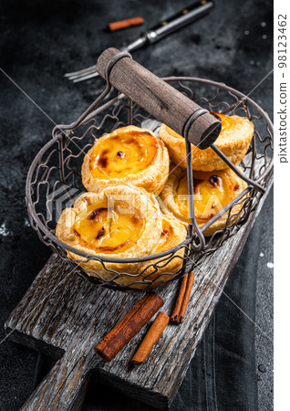 Traditional Lisbon Pasteis de nata in a basket. Black background. Top view 98123462