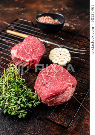 Raw Fillet Mignon Beef steaks, Dry aged tenderloin meat. Dark background. Top view 98123465