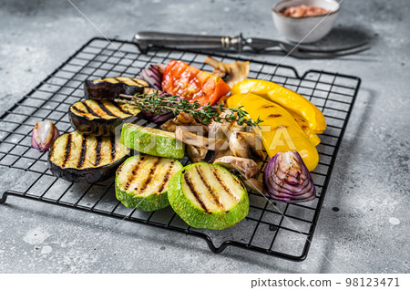 Seasonal summer Grilled vegetables on a grill, bell pepper, zucchini, eggplant, onion and tomato. Gray background. Top view 98123471