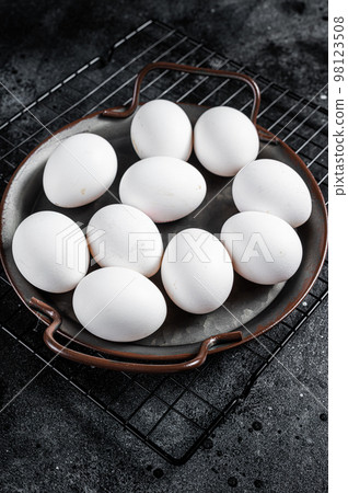 Plate with organic farm white chicken eggs. Black background. Top view 98123508
