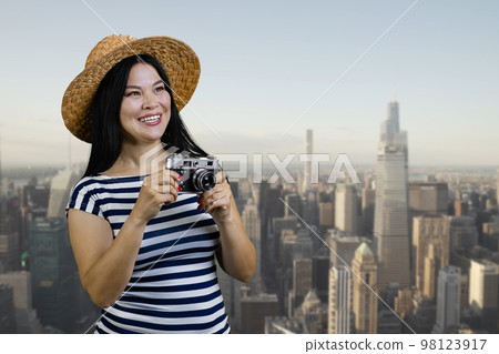 Happy young tourist korean woman with vintage photo camera. City scape background. Happy young tourist korean woman with vintage photo camera. City scape background. 98123917
