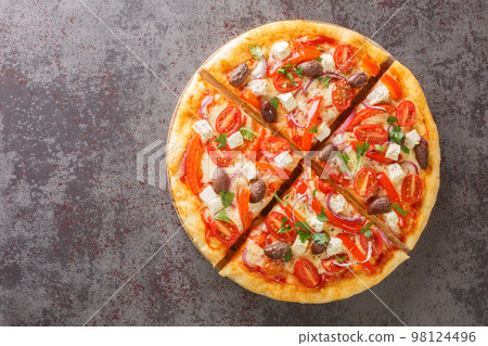 Sliced Greek pizza with olive, tomato, Mozzarella and feta cheese, onions, pepper. Horizontal top view 98124496