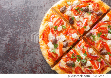 Homemade Greek pizza featuring feta, roasted red peppers, olive, tomato, onions closeup on wooden board. Horizontal top view Homemade Greek pizza featuring feta, roasted red peppers, olive, tomato, onions closeup on wooden board. Horizontal top view 98124498