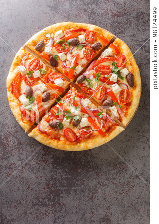 Vegetarian Greek pizza with peppers, feta, onions, tomatoes, olives and herbs close-up on a wooden board. Vertical top view Vegetarian Greek pizza with peppers, feta, onions, tomatoes, olives and herbs close-up on a wooden board. Vertical top view 98124499