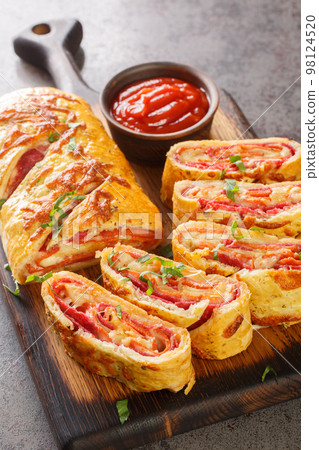 Homemade Stromboli pizza with cheese, pepperoni, salami closeup on the wooden board. Vertical Homemade Stromboli pizza with cheese, pepperoni, salami closeup on the wooden board. Vertical 98124520