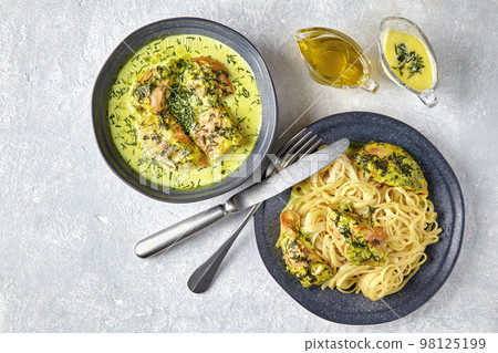 Fried chicken with spaghetti on dark plates on a gray concrete table 98125199