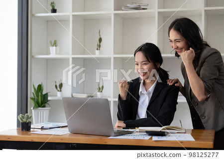 Group of Young Asian business team creative businesspeople coworker in office Happy to be successful partnership teamwork celebrating achievement and success concept 98125277