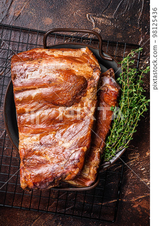 Smoked Barbecue Pork Ribs, Sparerib in kitchen tray. Dark background. Top view Smoked Barbecue Pork Ribs, Sparerib in kitchen tray. Dark background. Top view 98125436
