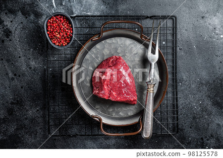 Piece of raw rump steak prepared for cooking. Black background. Top view 98125578