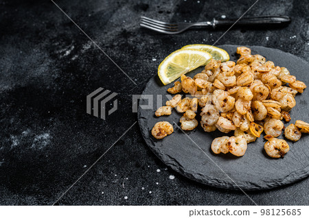 Roast peeled Shrimps prawns with garlic and olive oil, Cocktail shrimps. Black background. top view. copy space 98125685