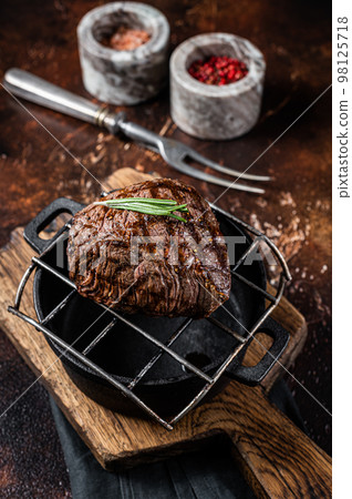 Roast Rump sirloin steak with spices on a grill. Dark background. Top view Roast Rump sirloin steak with spices on a grill. Dark background. Top view 98125718