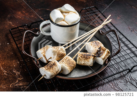Fried Marshmallow on the sticks with Cup of coffee. Dark background. Top view 98125721