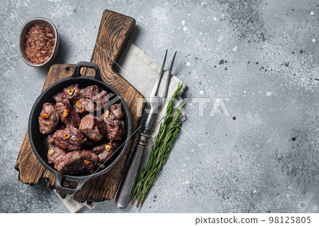 Grilled Sauteed Diced Beef in a skillet with garlic. Gray background. Top view. Copy space 98125805