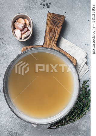 Bone meat chicken broth in a plate. Gray background. Top view 98125958