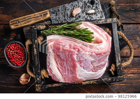 Organic uncooked Pork belly, raw bacon meat in a wooden plate with thyme. Wooden background. Top view Organic uncooked Pork belly, raw bacon meat in a wooden plate with thyme. Wooden background. Top view 98125966