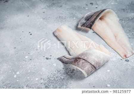 Two raw haddock fish fillets on kitchen table. Gray background. Top view. Copy space 98125977