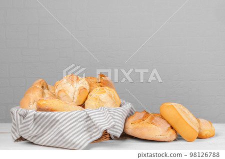 Fresh italian wheat breads in the basket on the table on white wall background. copy space Fresh italian wheat breads in the basket on the table on white wall background. copy space 98126788