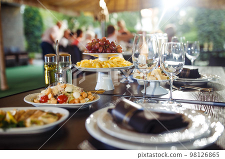 Sparkling glassware stands on long table prepared for wedding dinner. 98126865