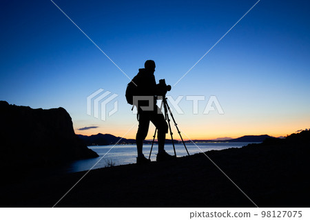 Silhouette of photographer on top of mountain 98127075