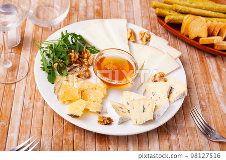 Various types of cheese on white plate Various types of cheese on white plate 98127516