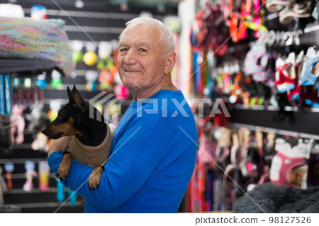 Old man with his dog in pet shop Old man with his dog in pet shop 98127526
