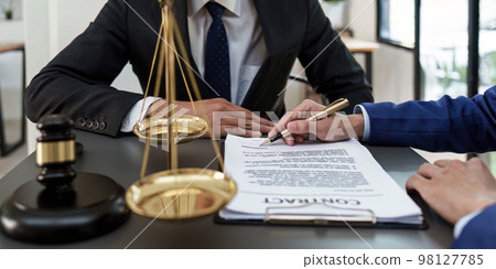 Business people and lawyers discussing contract papers with brass scale on wooden desk in office. Law, legal services, advice, Justice concept 98127785